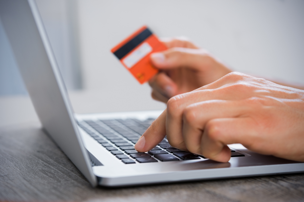 Person placing an online order with their laptop and credit card Person placing an online order with their laptop and credit card