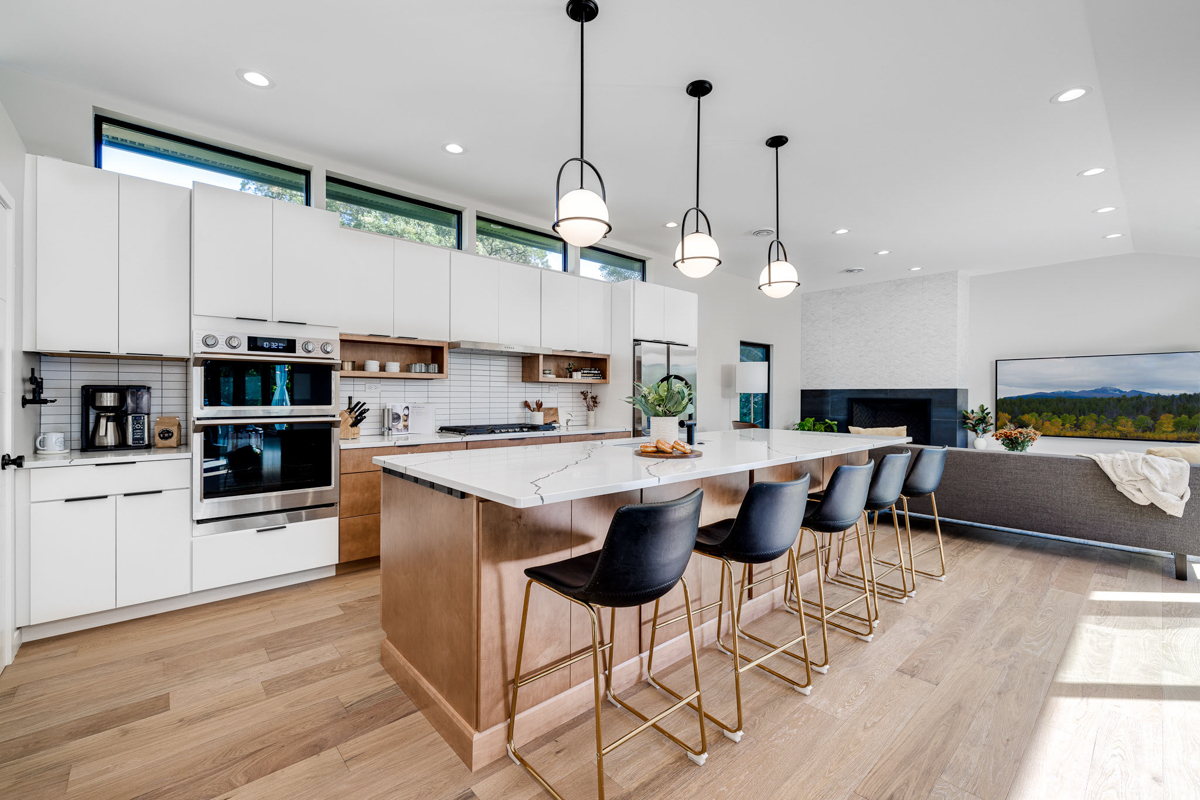 Mid-century modern kitchen design with white slab cabinets along one wall with warm wood base cabinets and accents plus a warm wood kitchen island and white quartz countertops Mid-century modern kitchen design with white slab cabinets along one wall with warm wood base cabinets and accents plus a warm wood kitchen island and white quartz countertops
