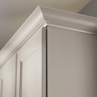 Tall Molding Decorative white kitchen cabinets with transitional curvy crown molding above.