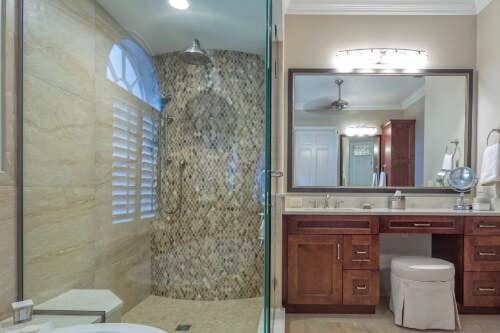 Traditional bathroom with red-stained vanity Traditional bathroom with red-stained vanity and glass walk-in shower