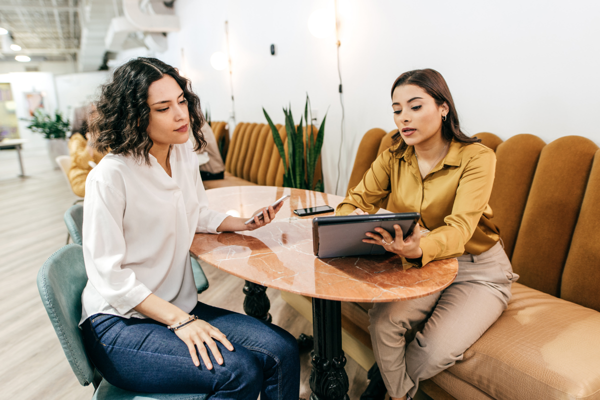 Two professional women meeting at a cafe Two professional women meeting at a cafe to talk about business