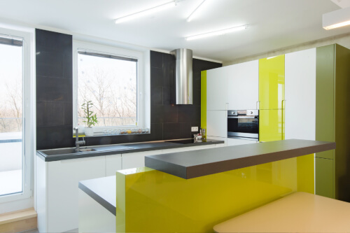 U-shaped white high-gloss kitchen cabinets with lime green accent cabinets, dark gray quartz countertops and a stainless round chimney hood U-shaped white high-gloss kitchen cabinets with lime green accent cabinets, dark gray quartz countertops and a stainless round chimney hood