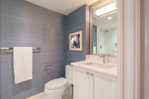 White shaker vanity with white countertops White shaker vanity with white countertops in a blue bathroom