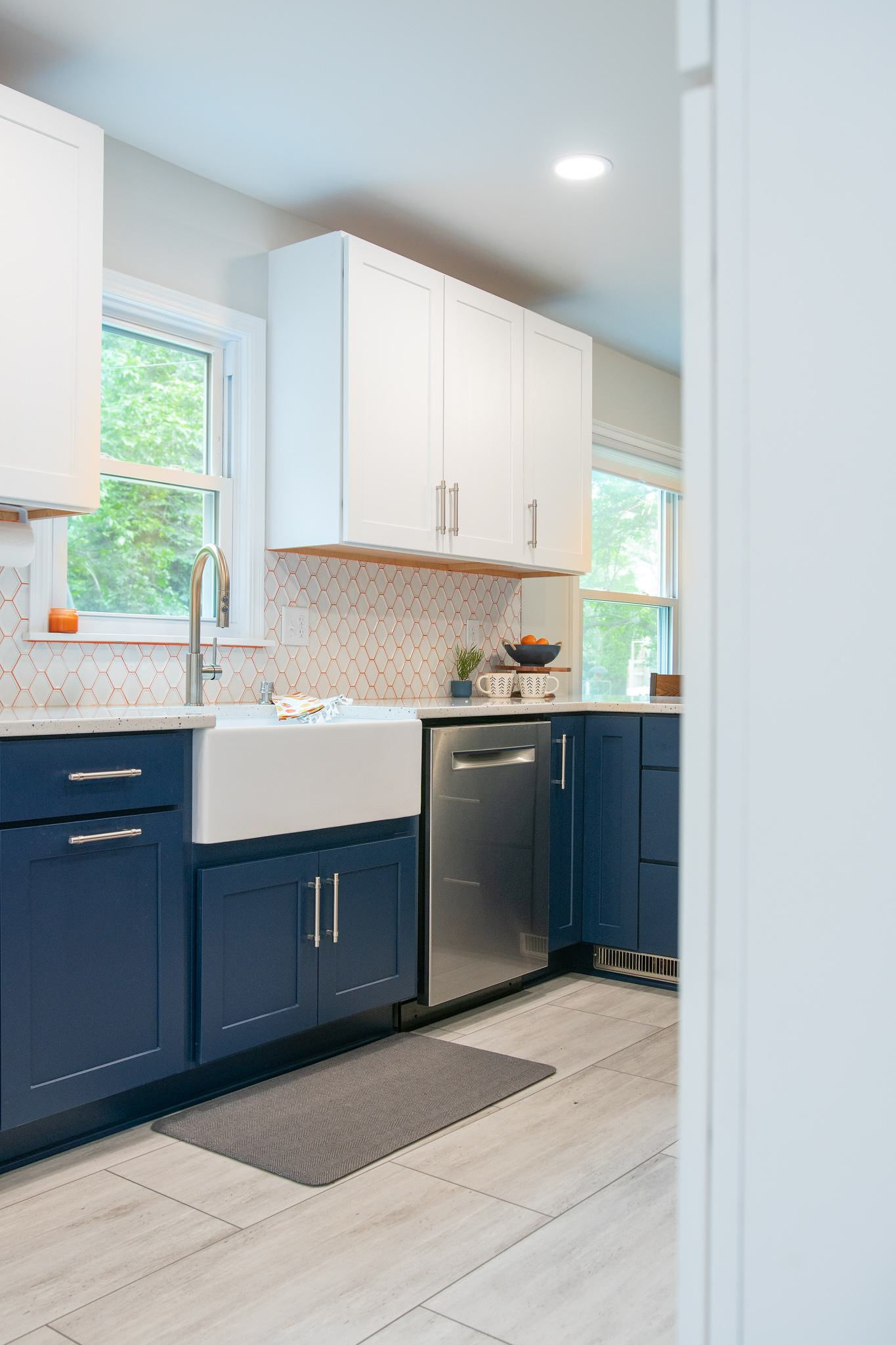 CliqStudios project: White and blue shaker kitchen cabinets with apron sink and white tile backsplash with orange grout CliqStudios project: White and blue shaker kitchen cabinets with apron sink and white tile backsplash with orange grout