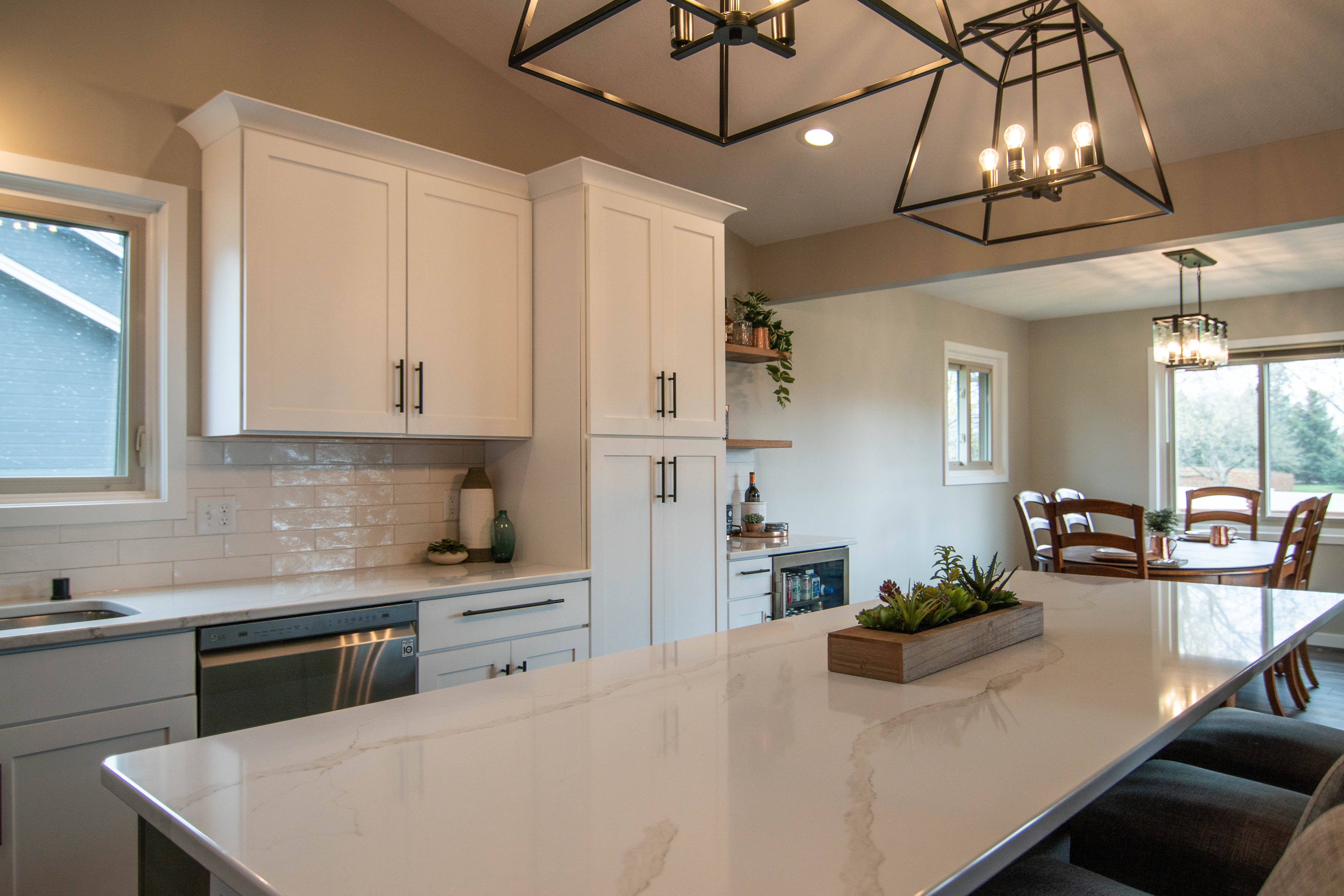 CliqStudios project: White shaker kitchen cabinets with a gray island, white quartz countertops and bronze accents CliqStudios project: White shaker kitchen cabinets with a gray island, white quartz countertops and bronze accents