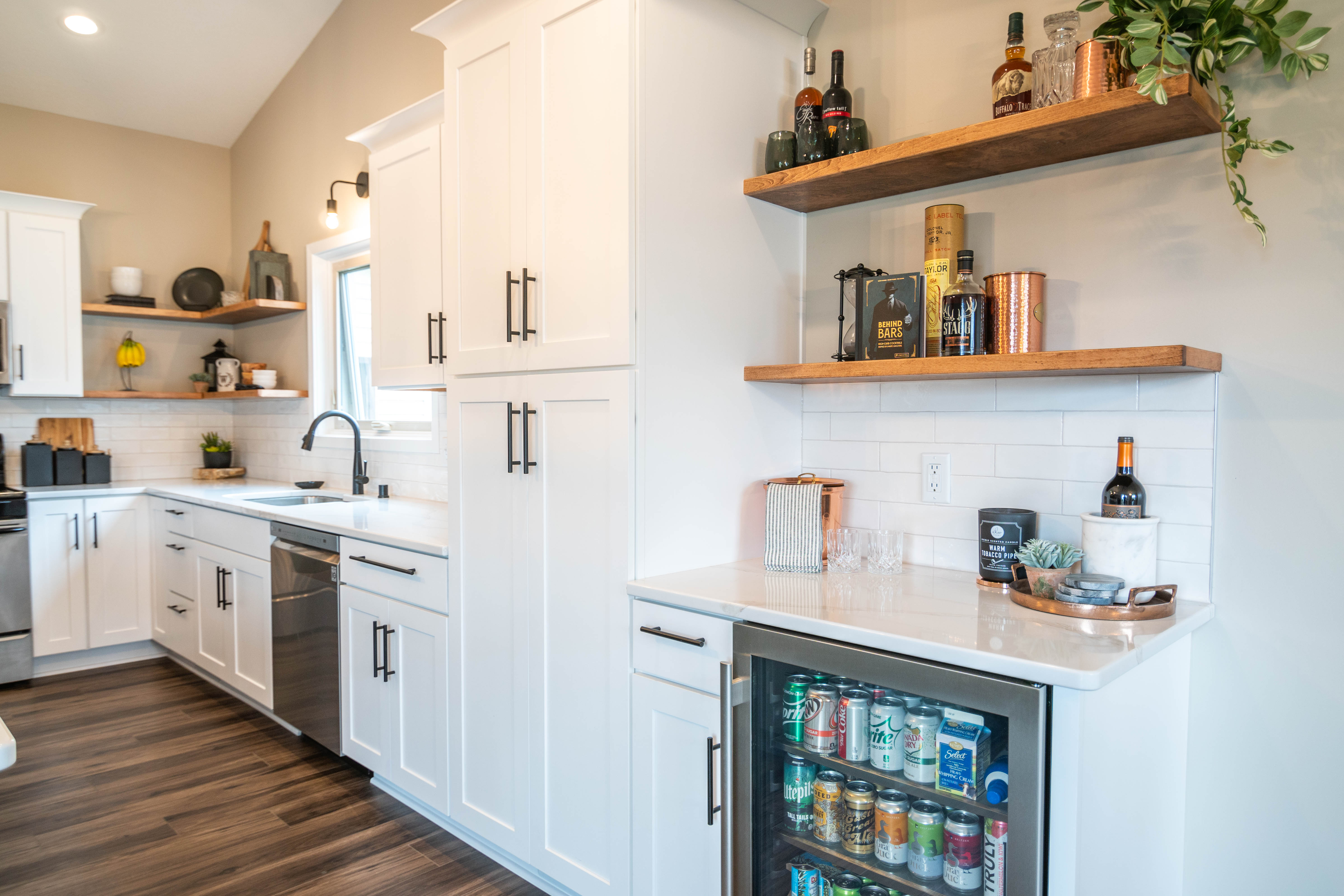 CliqStudios project: White shaker kitchen cabinets with a gray island, white quartz countertops, wood floating shelves, and bronze accents CliqStudios project: White shaker kitchen cabinets with a gray island, white quartz countertops, wood floating shelves, and bronze accents