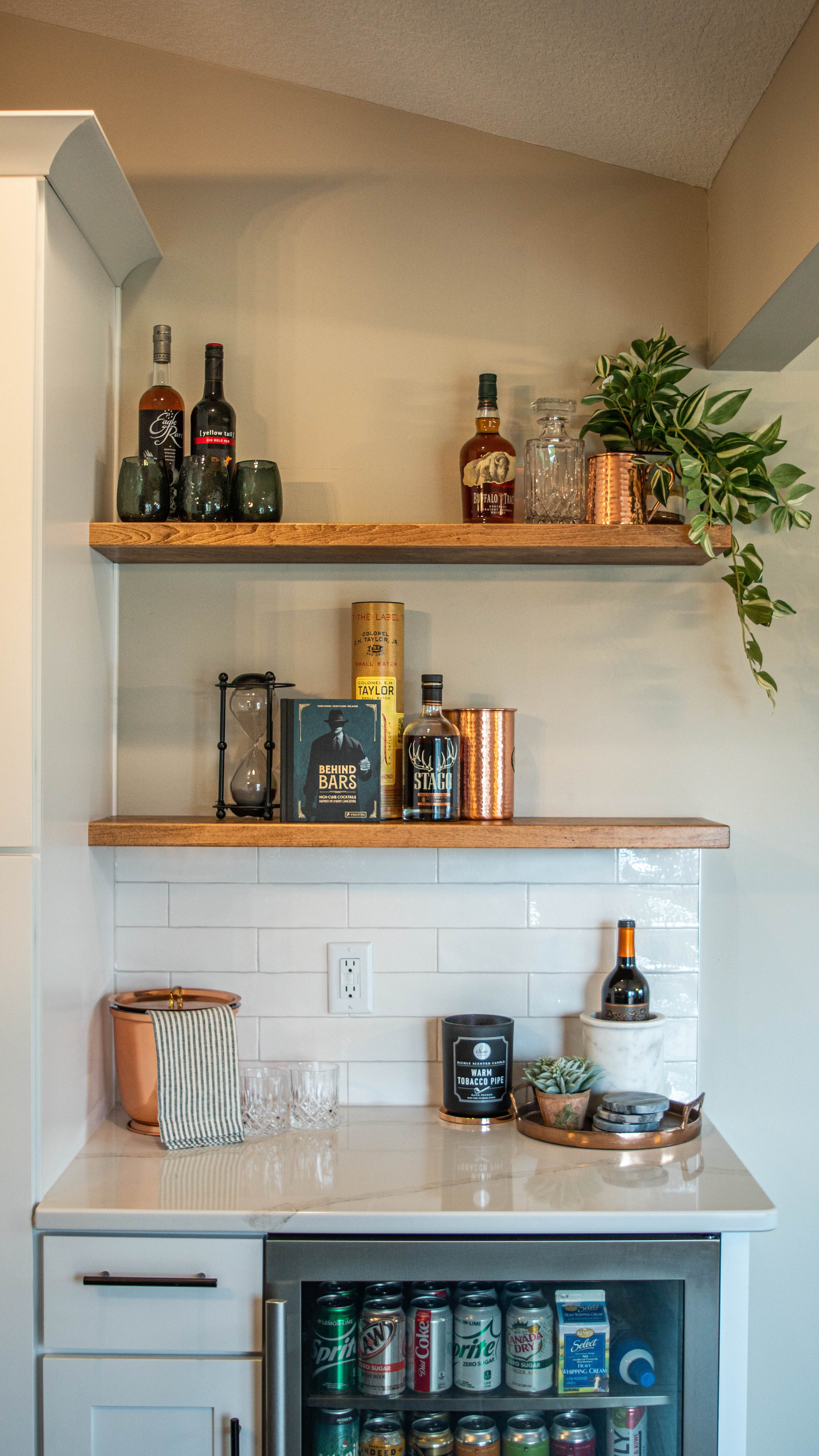CliqStudios project: White shaker kitchen cabinets with white quartz countertops, wood floating shelves, and bronze accents CliqStudios project: White shaker kitchen cabinets with white quartz countertops, wood floating shelves, and bronze accents