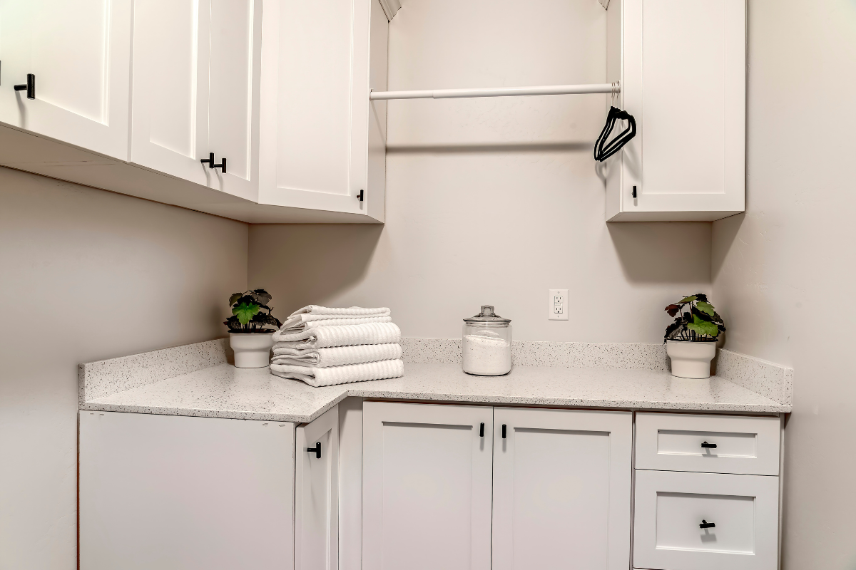 White shaker cabinet laundry room design with hanging rod above White shaker cabinet laundry room design with hanging rod above