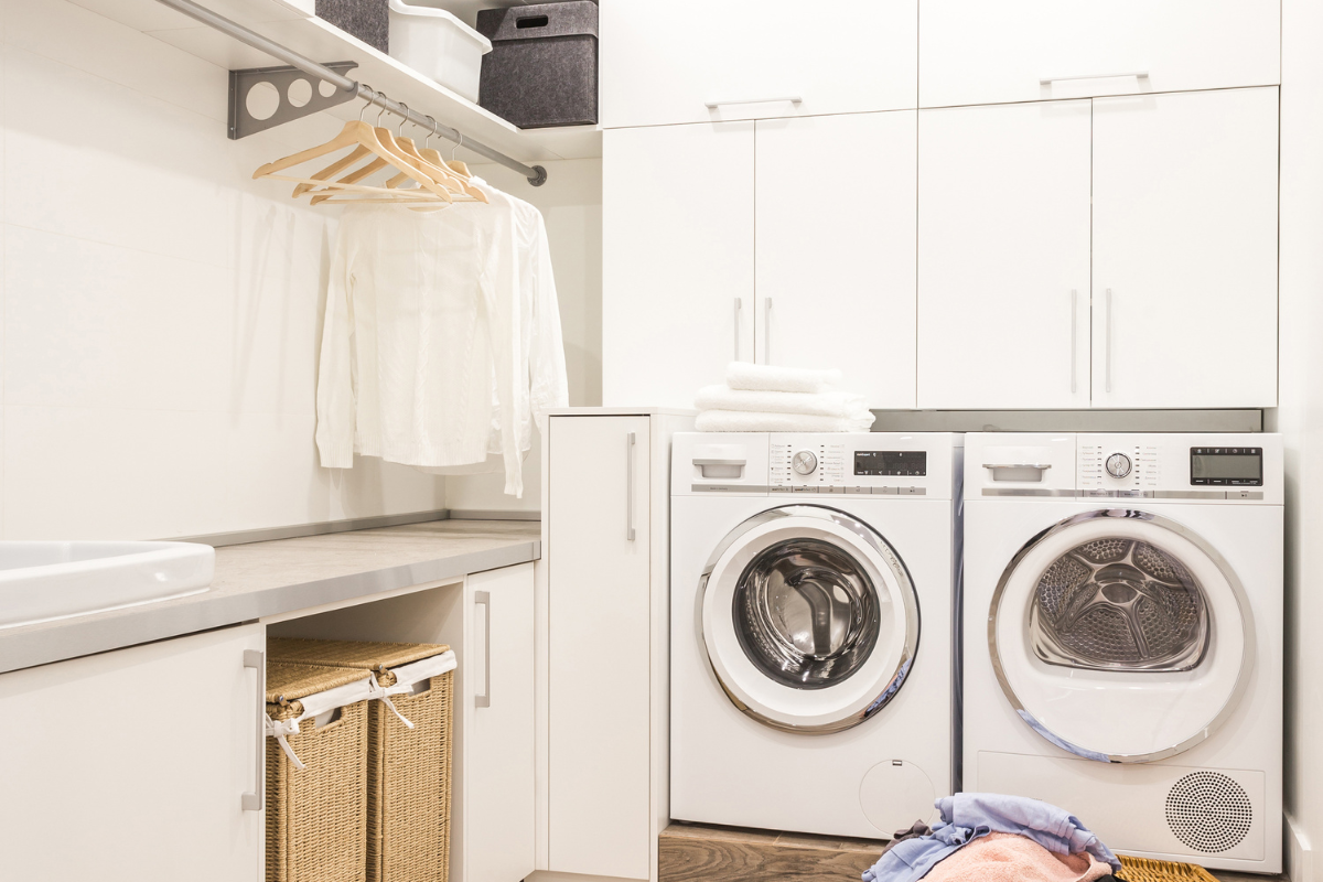 White slab laundry room cabinets with hanging rod for drying clothes White slab laundry room cabinets with hanging rod for drying clothes