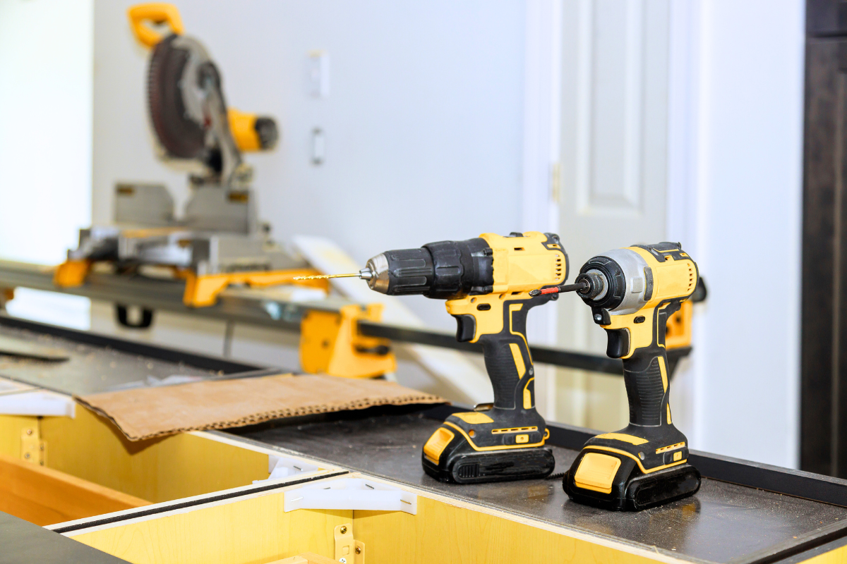 Two yellow power drills sitting on a countertop in a room being remodeled Two yellow power drills sitting on a countertop in a room being remodeled