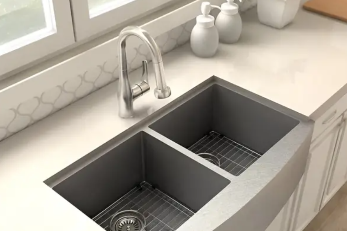 Chrome pull-down kitchen faucet on a stainless steel farm sink Chrome pull-down kitchen faucet on a stainless steel farm sink