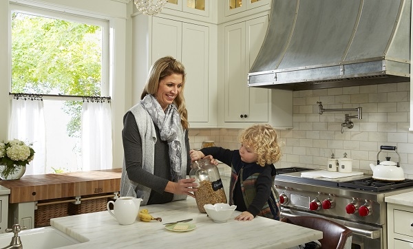 woman and small boy at center island in kitchen in older home woman and small boy at center island in kitchen in older home