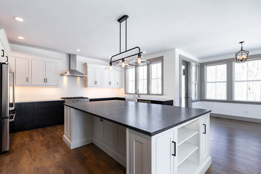 Large kitchen and island with white inset wall cabinets and dark brown base, and a white island with quartz countertops Large kitchen and island with white inset wall cabinets and dark brown base, and a white island with quartz countertops