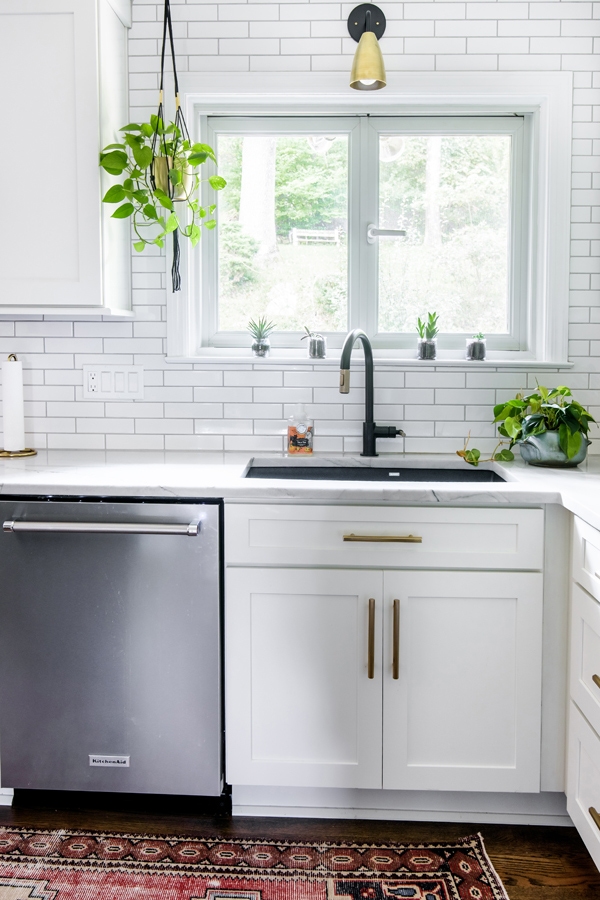 Kitchen corner with CliqStudios white Shaker cabinets, dark sink, and stainless-steel washing machine. Kitchen corner with CliqStudios white Shaker cabinets, dark sink, and stainless-steel washing machine.