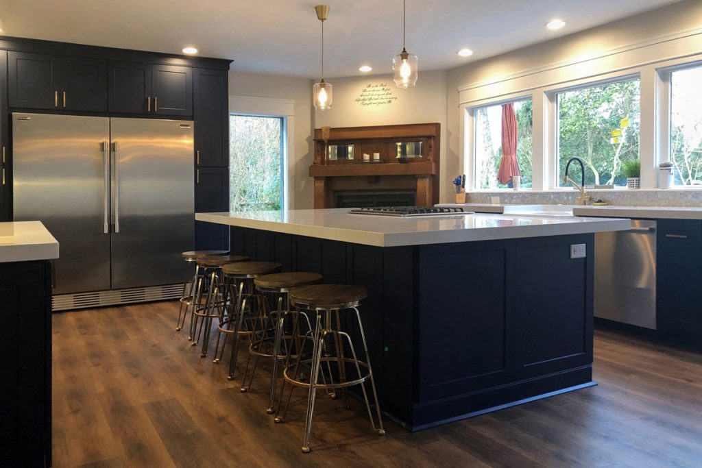 Blue and white kitchen with island seating facing large window above sink Blue and white kitchen with island seating facing large window above sink
