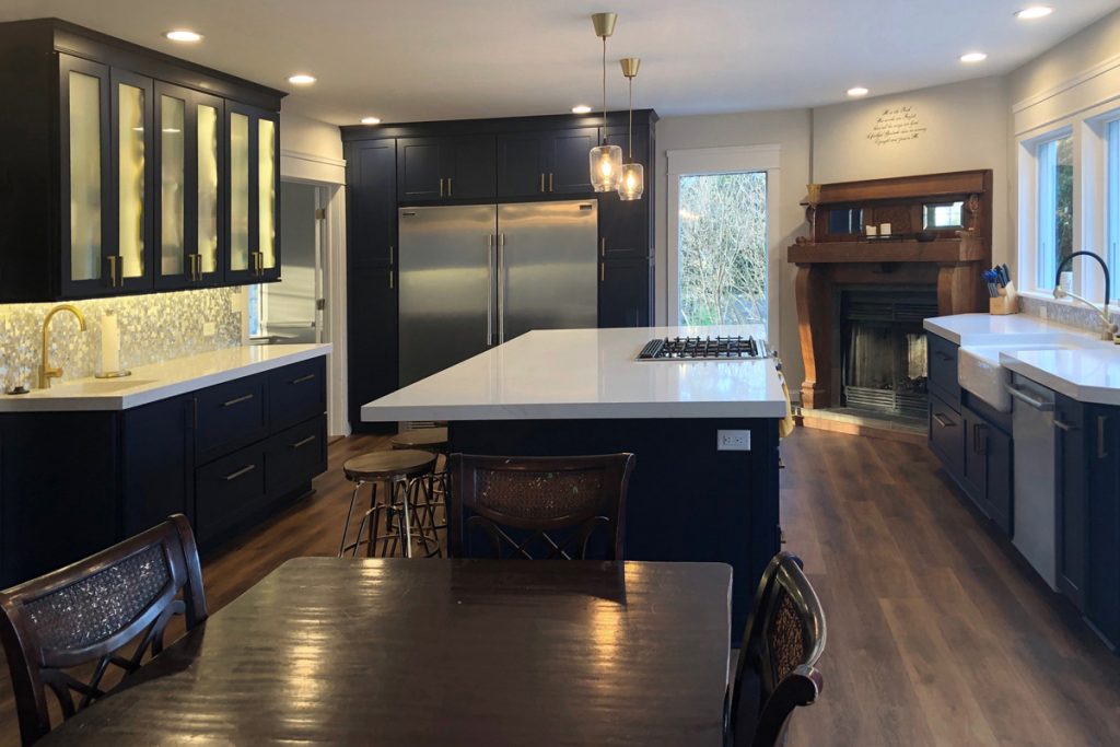 Dining room opens to a large kitchen with blue cabinets, island and large windows Dining room opens to a large kitchen with blue cabinets, island and large windows