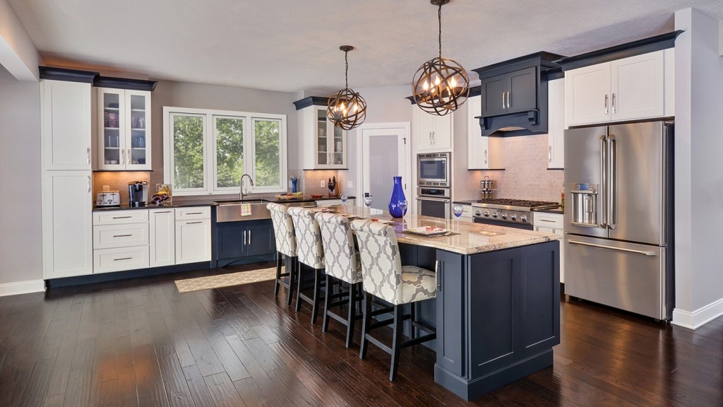 Beautifully designed open floor plan kitchen features painted shaker style cabinetry by CliqStudios. Shown Dayton shaker cabinet style in painted White finish and paired with Shaker in painted Black finish. Beautifully designed open floor plan kitchen features painted shaker style cabinetry by CliqStudios. Shown Dayton shaker cabinet style in painted White finish and paired with Shaker in painted Black finish.