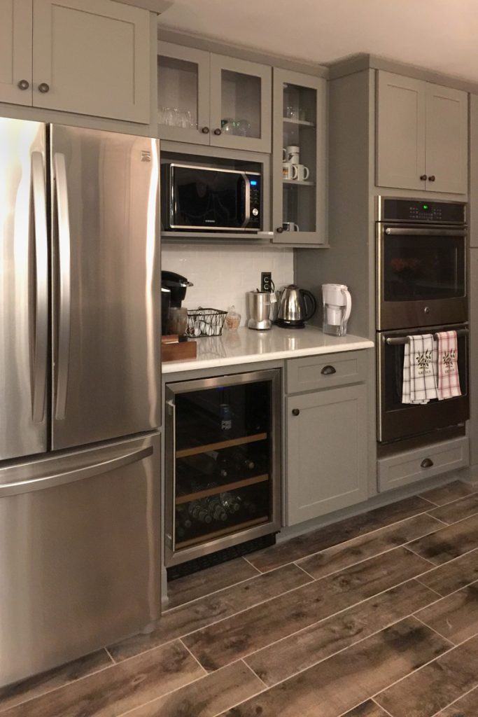 Kitchen beverage center with gray cabinets, wine fridge and glass front cabinets Kitchen beverage center with gray cabinets, wine fridge and glass front cabinets