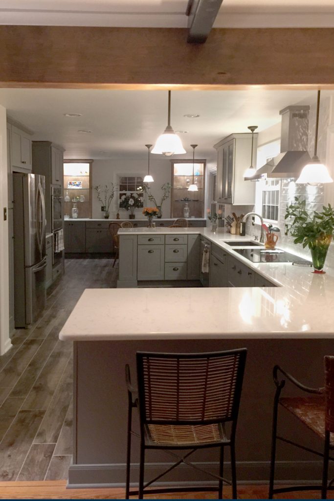 Kitchen with gray cabinets and exposed wood beams opens to the dining area Kitchen with gray cabinets and exposed wood beams opens to the dining area