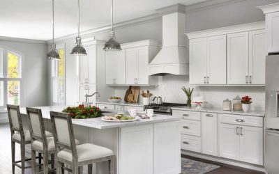 Open kitchen with white shaker cabinets, large island, white wood range hood with holiday decorations Open kitchen with white shaker cabinets, large island, white wood range hood with holiday decorations