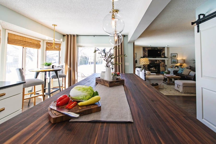 View of Kitchen dark wooden island top into the neighboring living room. View of Kitchen dark wooden island top into the neighboring living room.