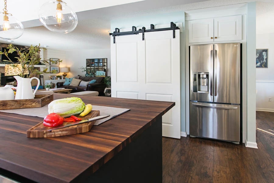Image of kitchen looking into the living area, and a white barn door. Image of kitchen looking into the living area, and a white barn door.