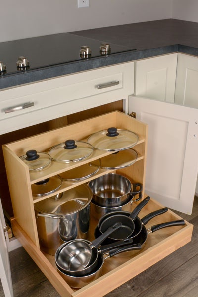 Pots and Pans pullout organizer, filled with pots and pans on the lowers roll out tray, and lids on the 2 shelves. Pots and Pans pullout organizer, filled with pots and pans on the lowers roll out tray, and lids on the 2 shelves.