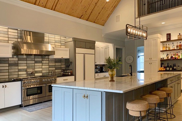 Slab white kitchen cabinets with large shaker gray island and oil rubbed bronze light fixtures Slab white kitchen cabinets with large shaker gray island and oil rubbed bronze light fixtures