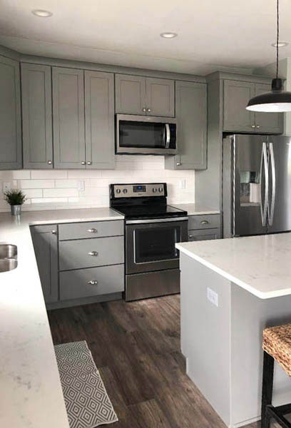 Medium gray kitchen cabinets with subway tile backsplash, stainless appliances and white countertops Medium gray kitchen cabinets with subway tile backsplash, stainless appliances and white countertops