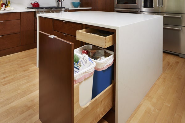 A Wastebasket cabinet in CliqStudios Studio 31 style in Cider finish containing a full trash can and full recycling bin. A Wastebasket cabinet in CliqStudios Studio 31 style in Cider finish containing a full trash can and full recycling bin.