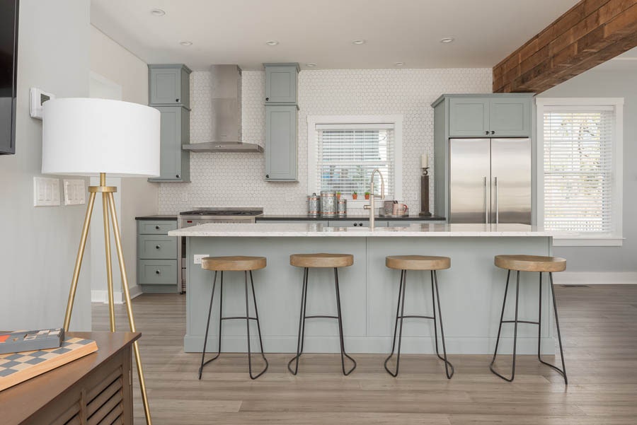 open kitchen with island seating for four with blue-gray cabinets and white backsplash up the wall open kitchen with island seating for four with blue-gray cabinets and white backsplash up the wall
