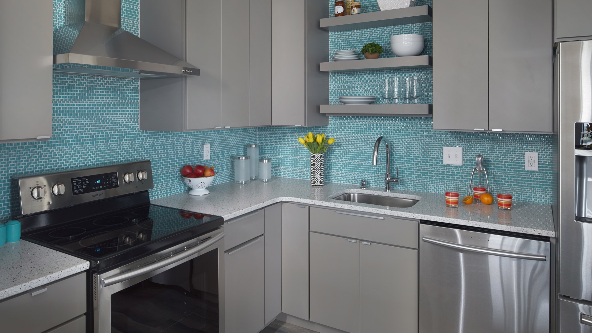 Modern kitchen featuring Gray Slab door style with blue blacksplash and black appliances. Modern kitchen featuring Gray Slab door style with blue blacksplash and black appliances.