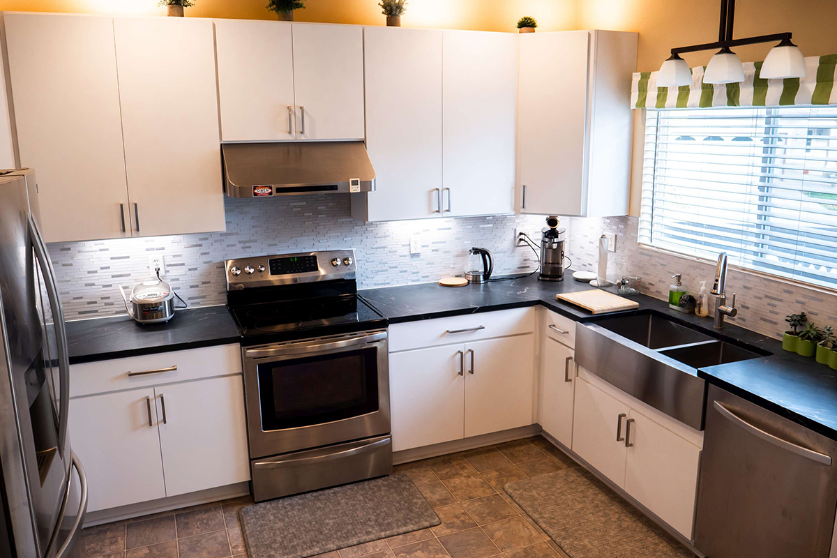 CliqStudios project: Slab white kitchen cabinets with stainless steel appliances and stainless steel apron sink CliqStudios project: Slab white kitchen cabinets with stainless steel appliances and stainless steel apron sink