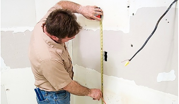 Contractor measuring wallboard in kitchen remodel Contractor measuring wallboard in kitchen remodel