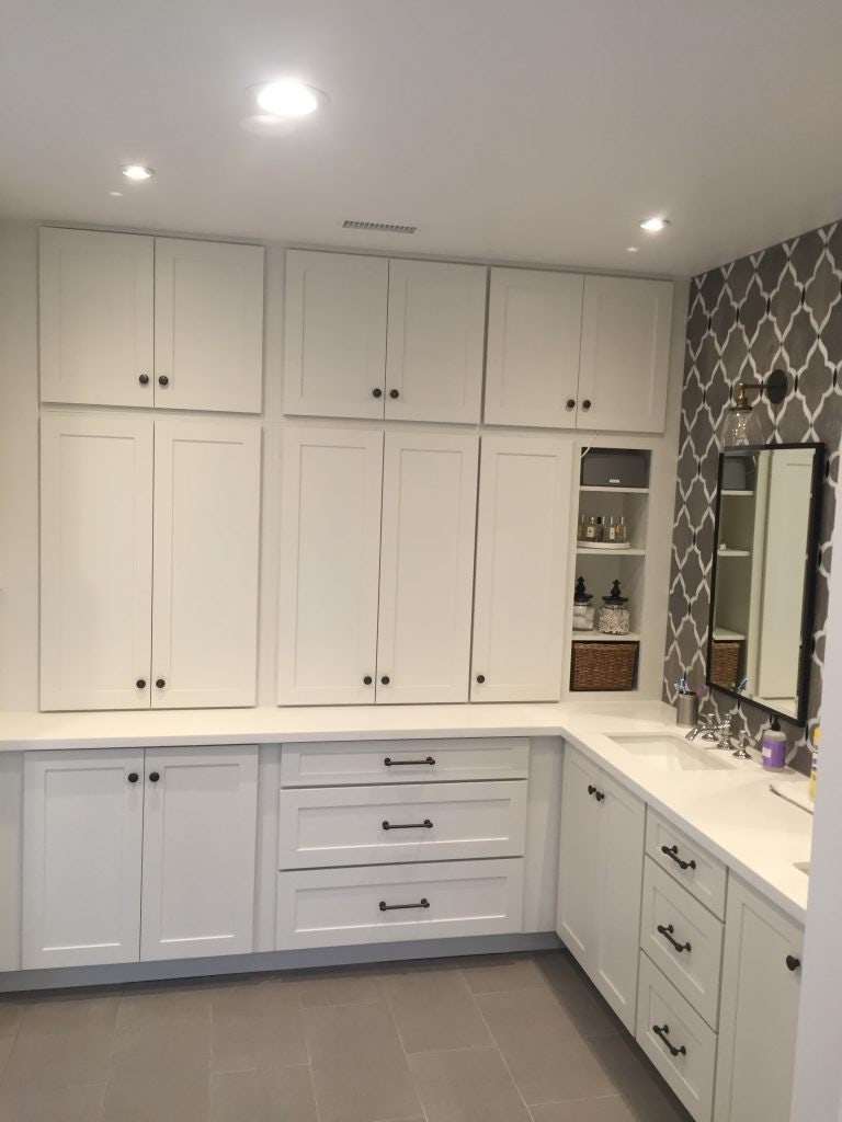 White shaker vanity cabinets Master bathroom with L-shaped white shaker vanity cabinets, double sinks and lots of pantry storage.