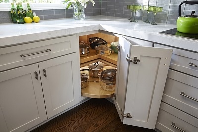 closeup of light gray shaker cabinets with lazy susan base open to display turntables closeup of light gray shaker cabinets with lazy susan base open to display turntables