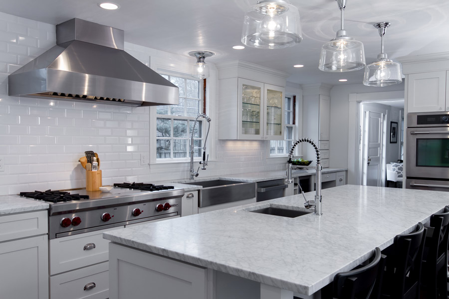 White shaker kitchen cabinets with large stainless range hood and island White shaker kitchen cabinets with large stainless range hood and island