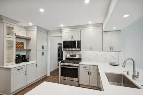 Light gray U-shaped shaker kitchen design with white quartz countertops Light gray U-shaped shaker kitchen design