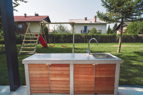  Outdoor kitchen with wood outdoor kitchen cabinets in modern red stain and corian countertops