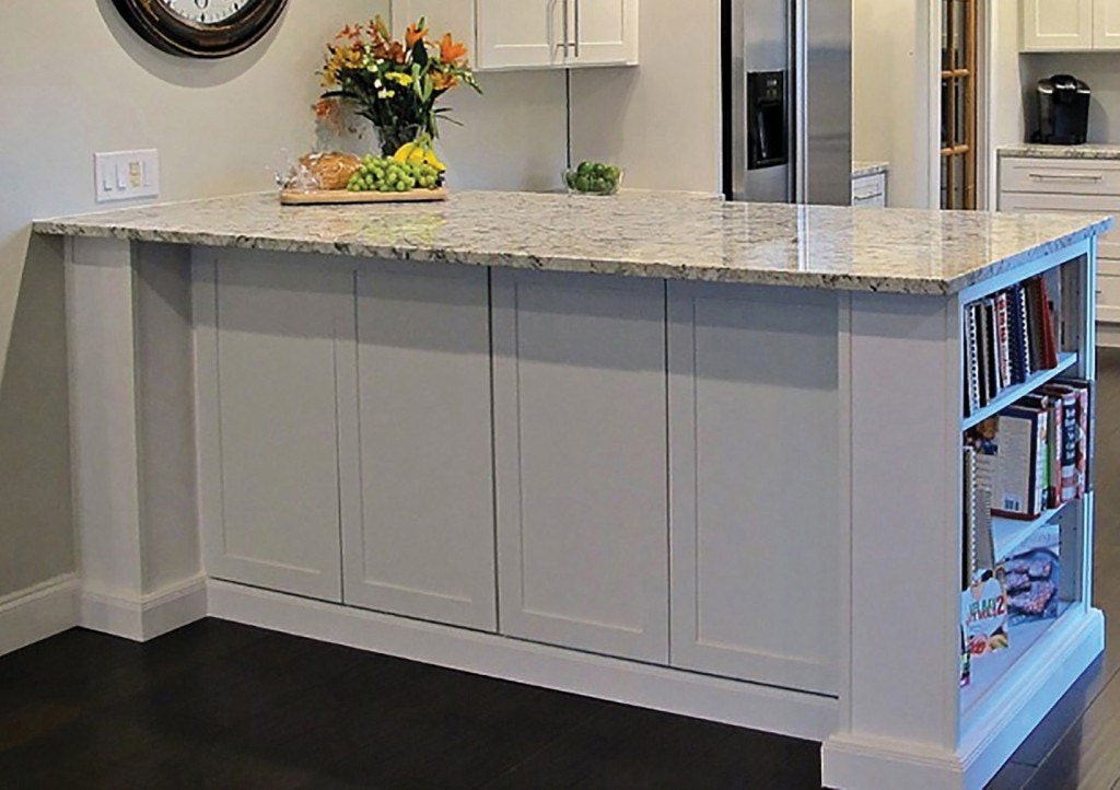 Kitchen peninsula in white cabinets with bookcase end, decorative door panels on back and ogee molding in toe kick Kitchen peninsula in white cabinets with bookcase end, decorative door panels on back and ogee molding in toe kick