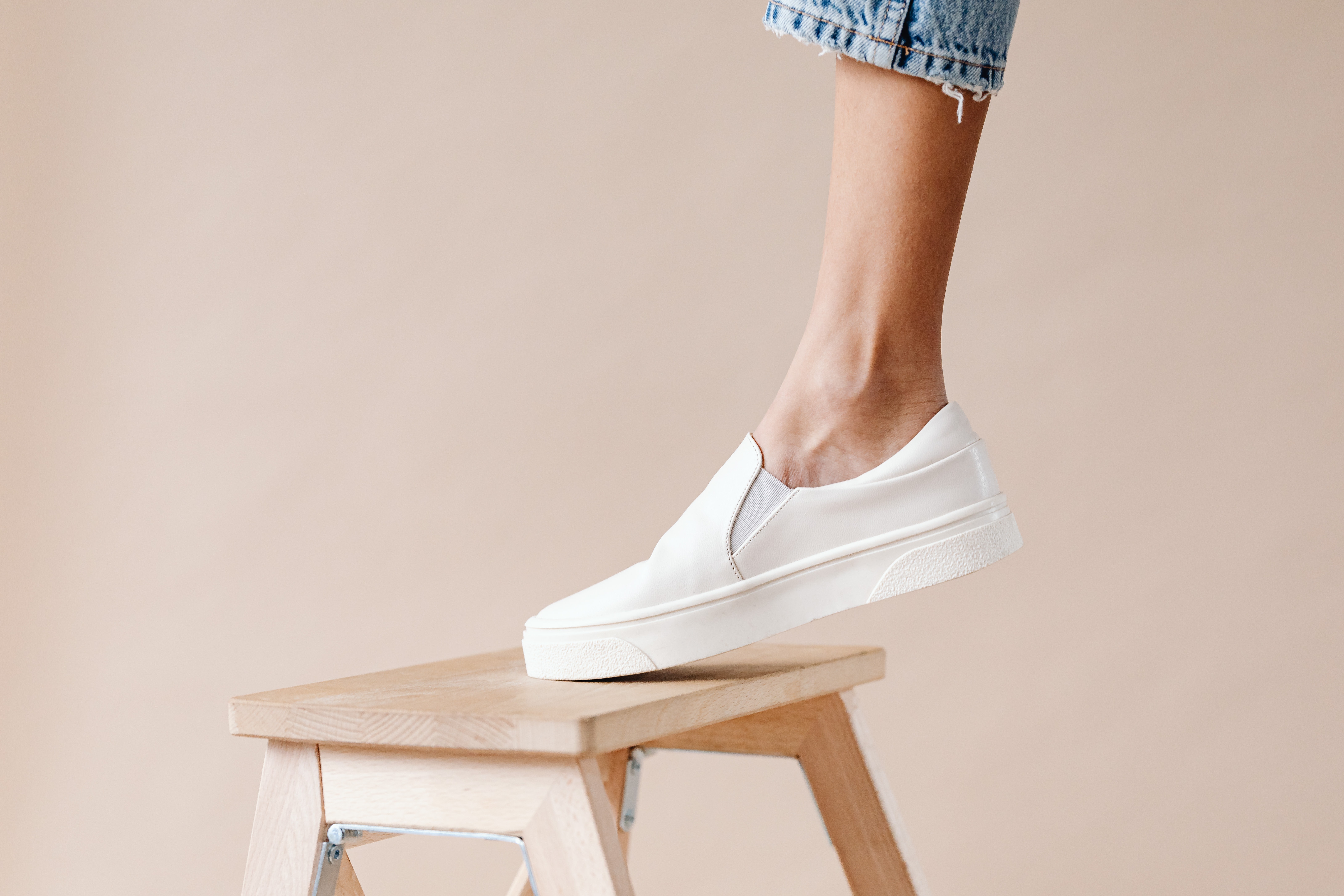 Person standing on a foldable step stool Person standing on a foldable step stool