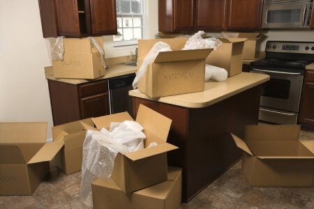 Old kitchen with labeled boxes for packing on the countertops.