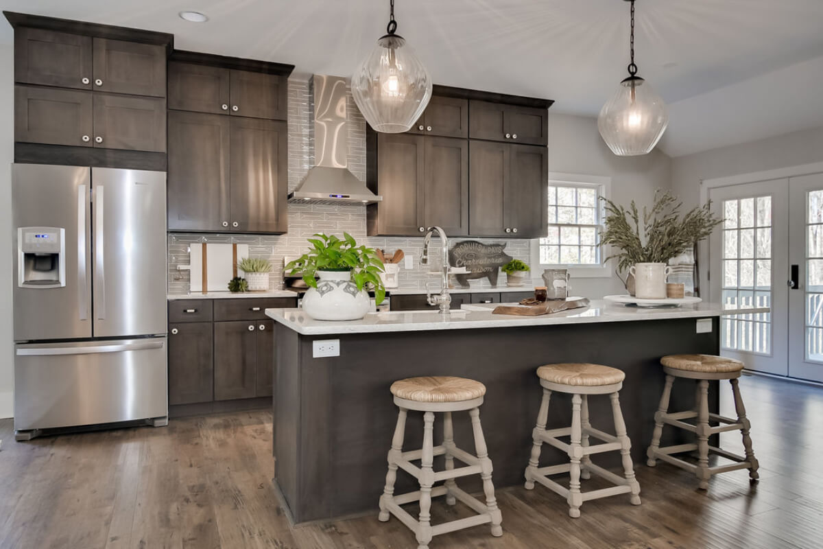 Dark brown shaker kitchen design with stacked cabinets, a kitchen island and cream-colored quartz countertops