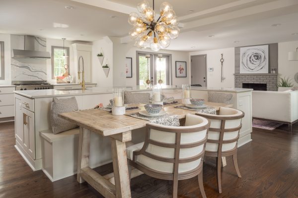 White shaker kitchen cabinets with built-in dining room bench behind island