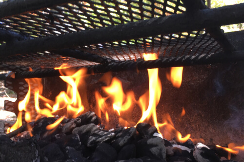Outdoor charcoal grill with fire inside.